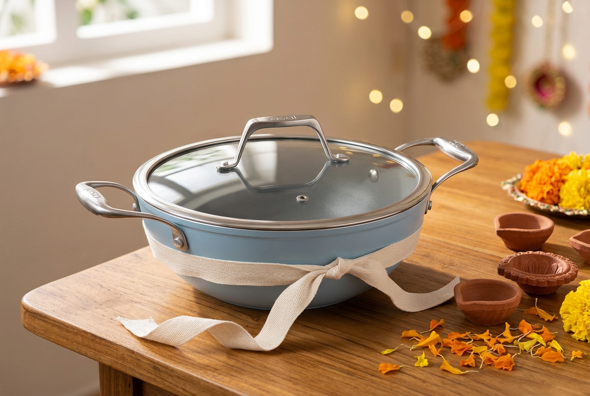Asai Pacific Blue ceramic kadai tied with a cream ribbon beside Diwali diyas and marigold petals